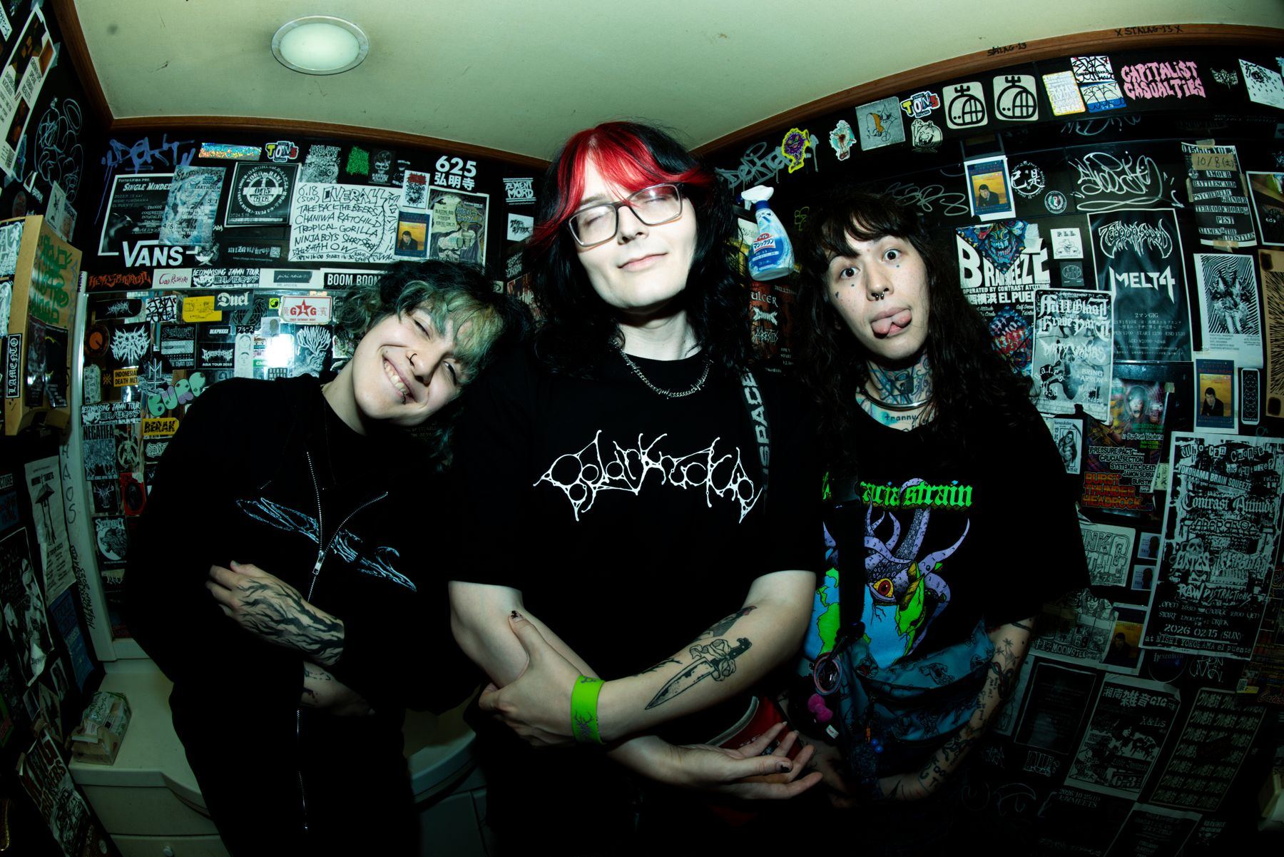 JISEI — Minerva, Alexis Page and Leda XO backstage in a sticker-covered room