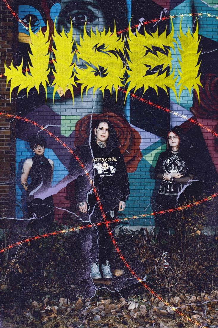 JISEI in front of a mural with the band logo